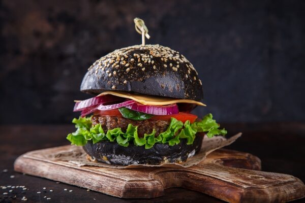 Kuro burger with a black bun, lettuce, tomato and patty