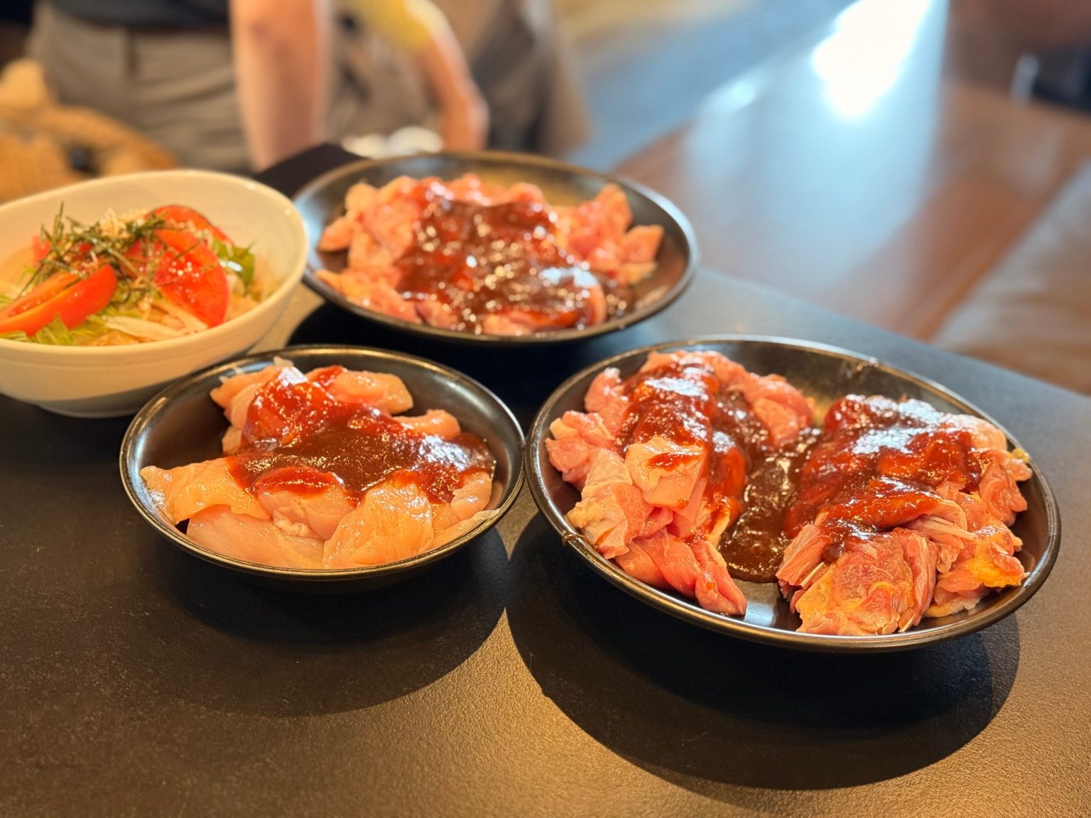 Plates of raw young chicken, old chicken and breast coated in miso sauce, with a daikon salad, at Shinya, Matsusaka