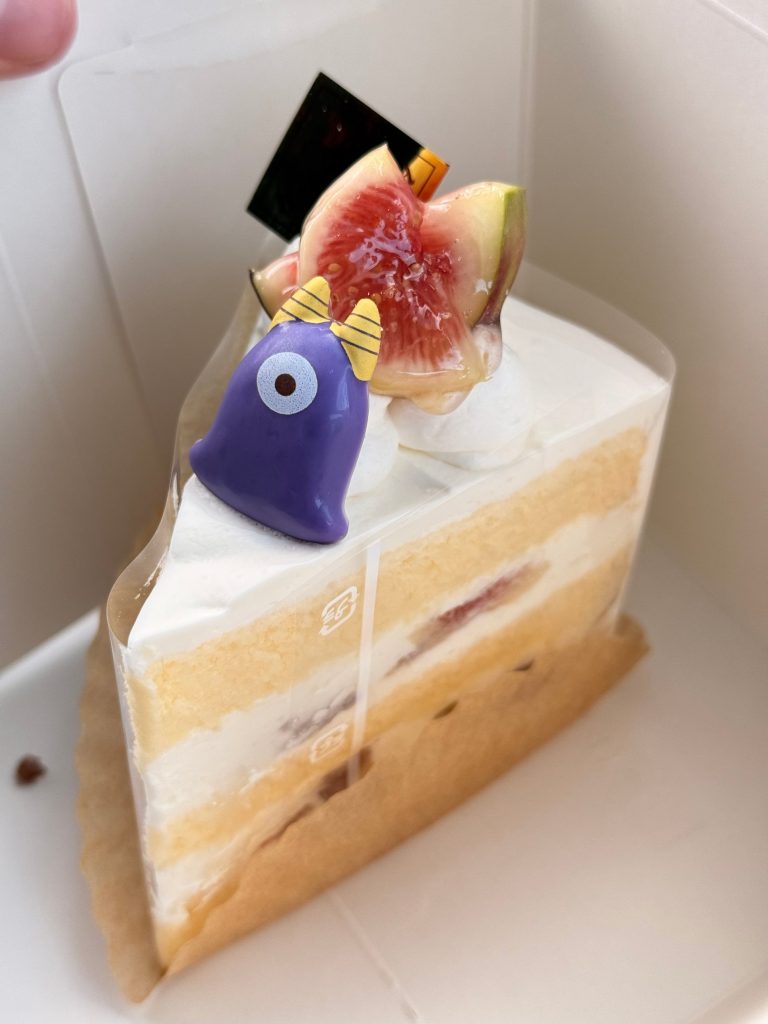 Fig shortcake slice topped with fresh fig and a purple Halloween monster decoration