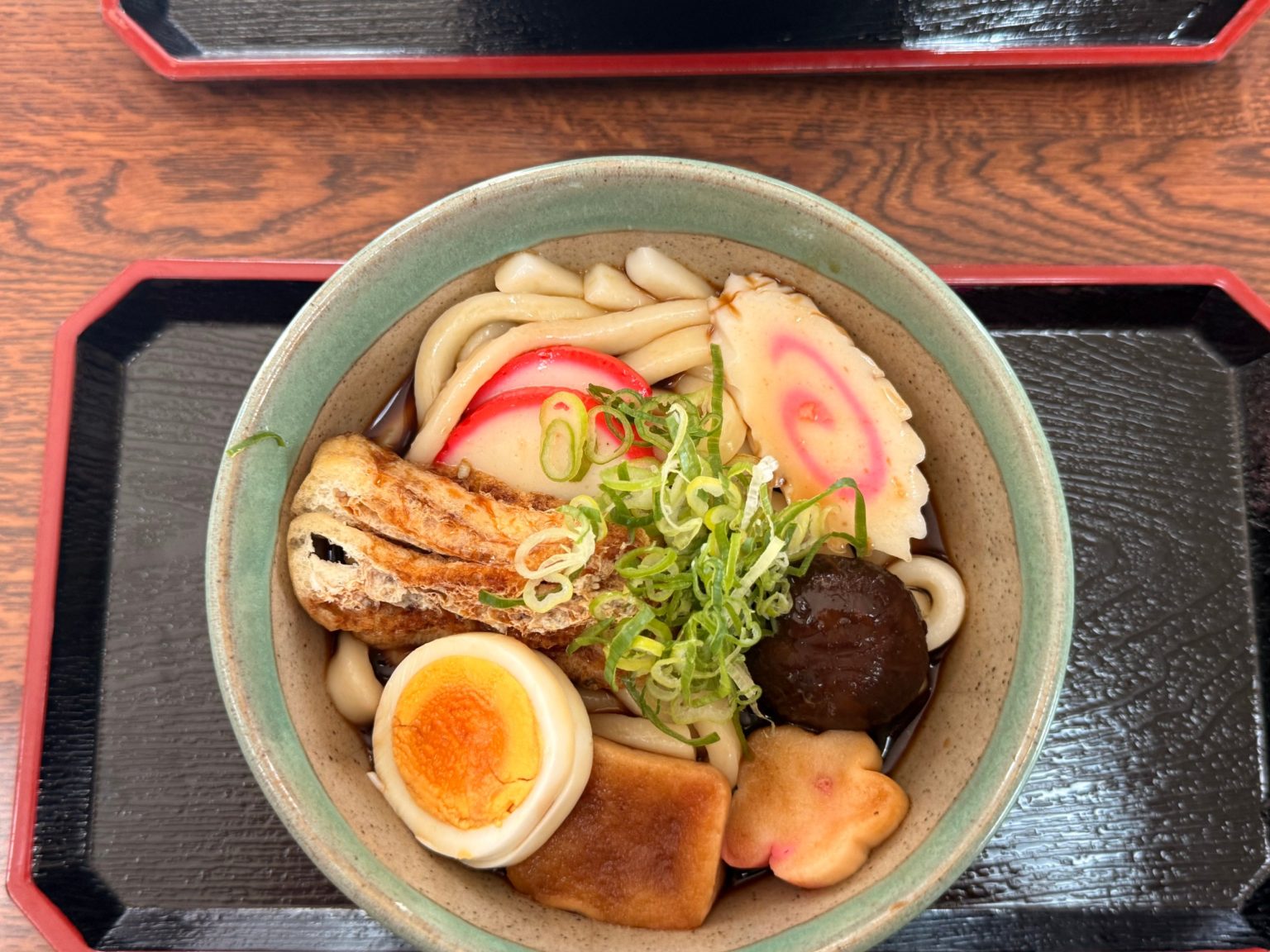Overhead view of Ise kayaku udon with fried tofu, fish cake, shiitake and boiled egg at Tsutaya, Ise