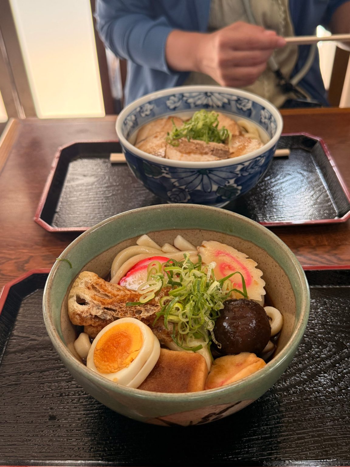 Ise kayaku udon in the foreground and roast-pork Ise udon behind it on lacquered trays at Tsutaya