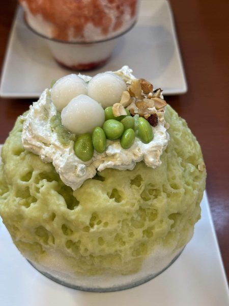 Matcha kakigori shaved ice topped with cream, shiratama dumplings and edamame