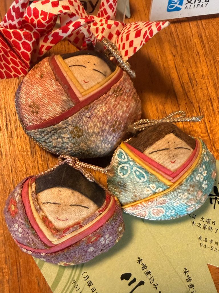 Small fabric doll ornaments on the counter at Kawaichi, Kuwana