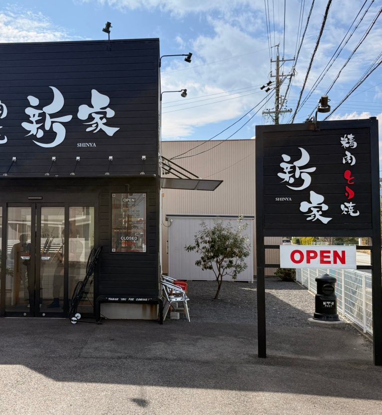 Black shopfront and roadside sign of Shinya chicken yakiniku restaurant in Matsusaka, Mie