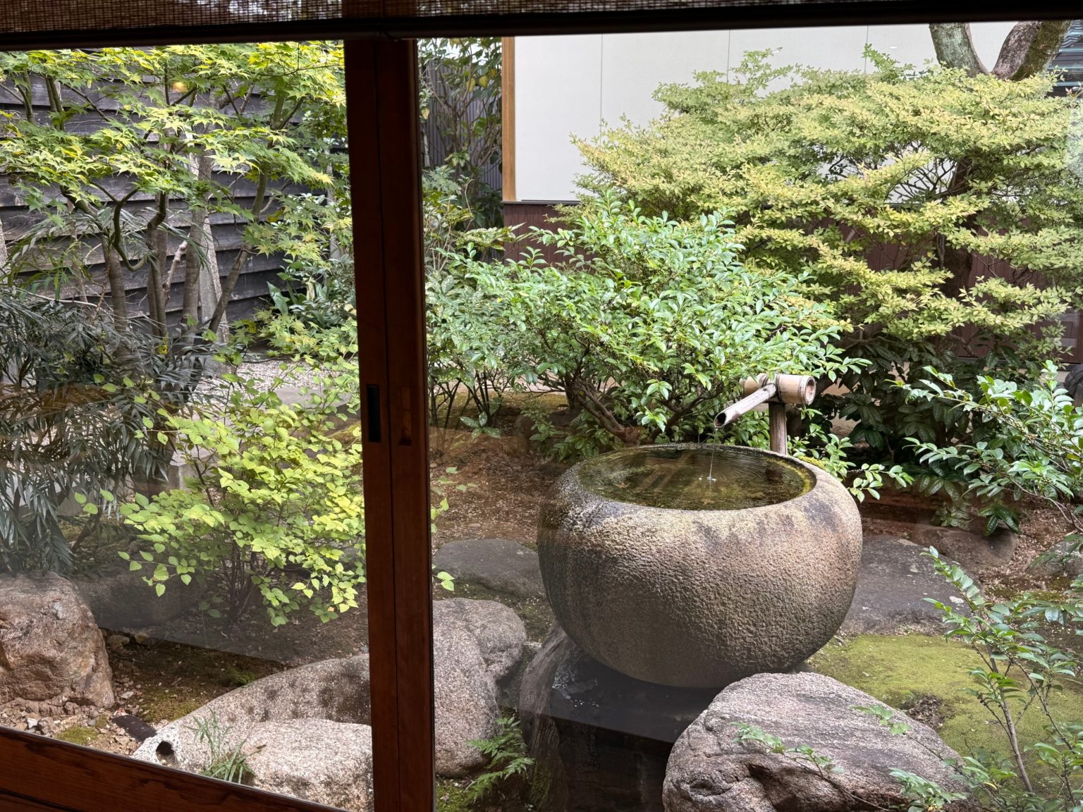 Round stone water basin with a bamboo spout in the garden at Sagan, Gifu
